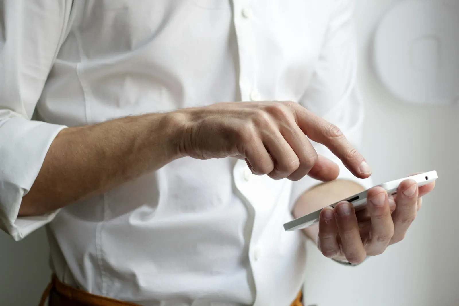 A hand holding a phone with a plain, quiet screen