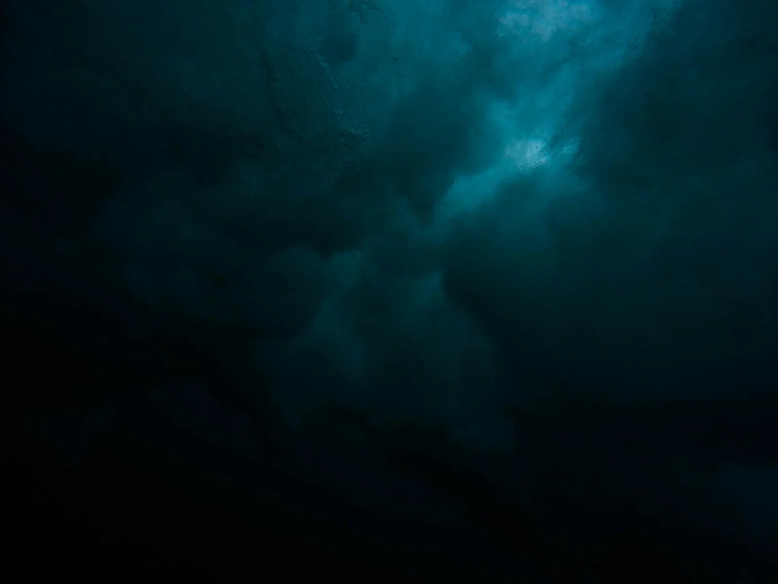 Dark storm clouds lit faintly from behind