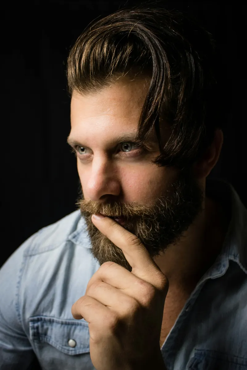 A man deep in thought, lit from one side